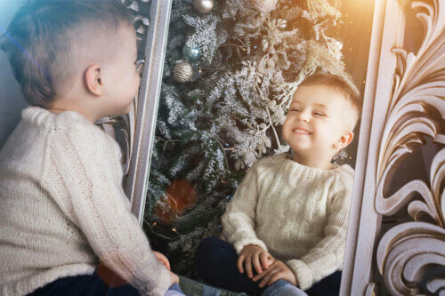 Un enfant qui parle avec le sourire dans le miroir.