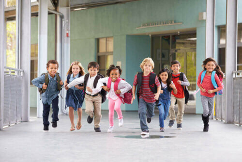 La rentrée d'école avec des enfants avec le cartable sur le dos.