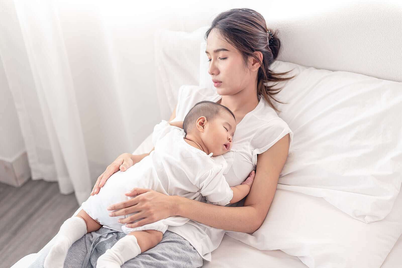 Une maman avec son enfant endormi sur le ventre.