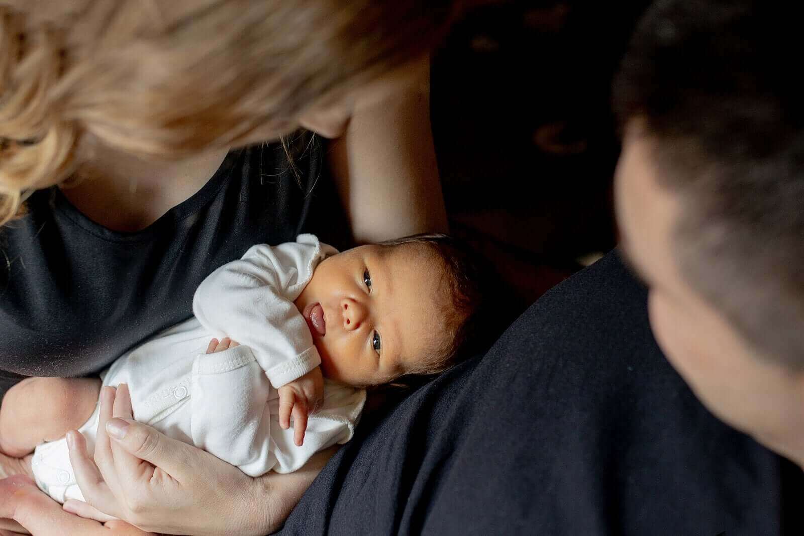 Des parents avec leur bébé dans les bras.