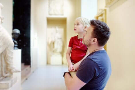 Un père qui visite un musée avec son enfant.