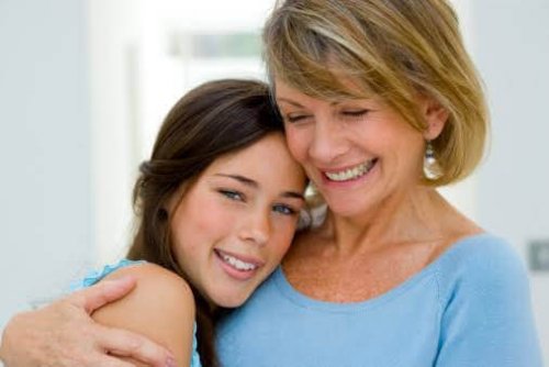 Une adolescente dans les bras de sa maman.