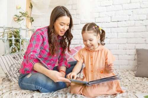 Une mère et sa fille lisent un livre.