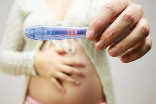 Une femme enceinte présente un test de grossesse.