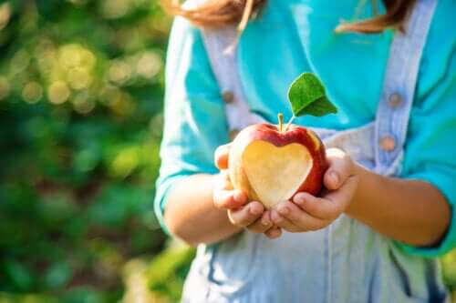 Apple avantages concept fille main coupant la forme du coeur à l'extérieur