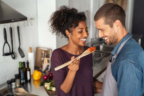 Heureux jeune couple cuisiner ensemble cuillère à dîner nourriture fertilité préconception