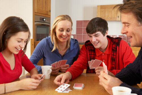 la famille joue aux cartes de table de jeu moment partagé loisirs temps libre