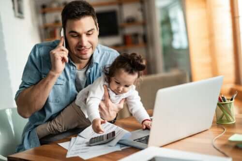 Père apprenant à réconcilier famille et travail avec sa fille dans ses bras.