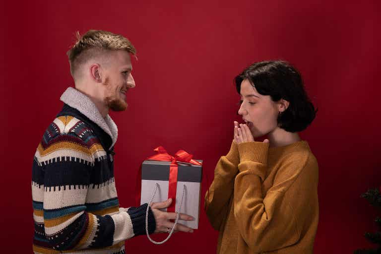Un homme qui offre un cadeau à sa partenaire.