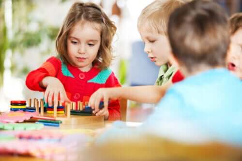 les enfants jouent avec des jouets en bois colorés triés sur la table de jardin