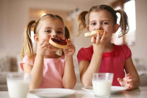 les filles mangent du pain avec de la confiture un verre de lait le petit déjeuner