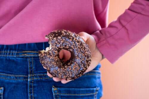 femme cache de la malbouffe sur son dos