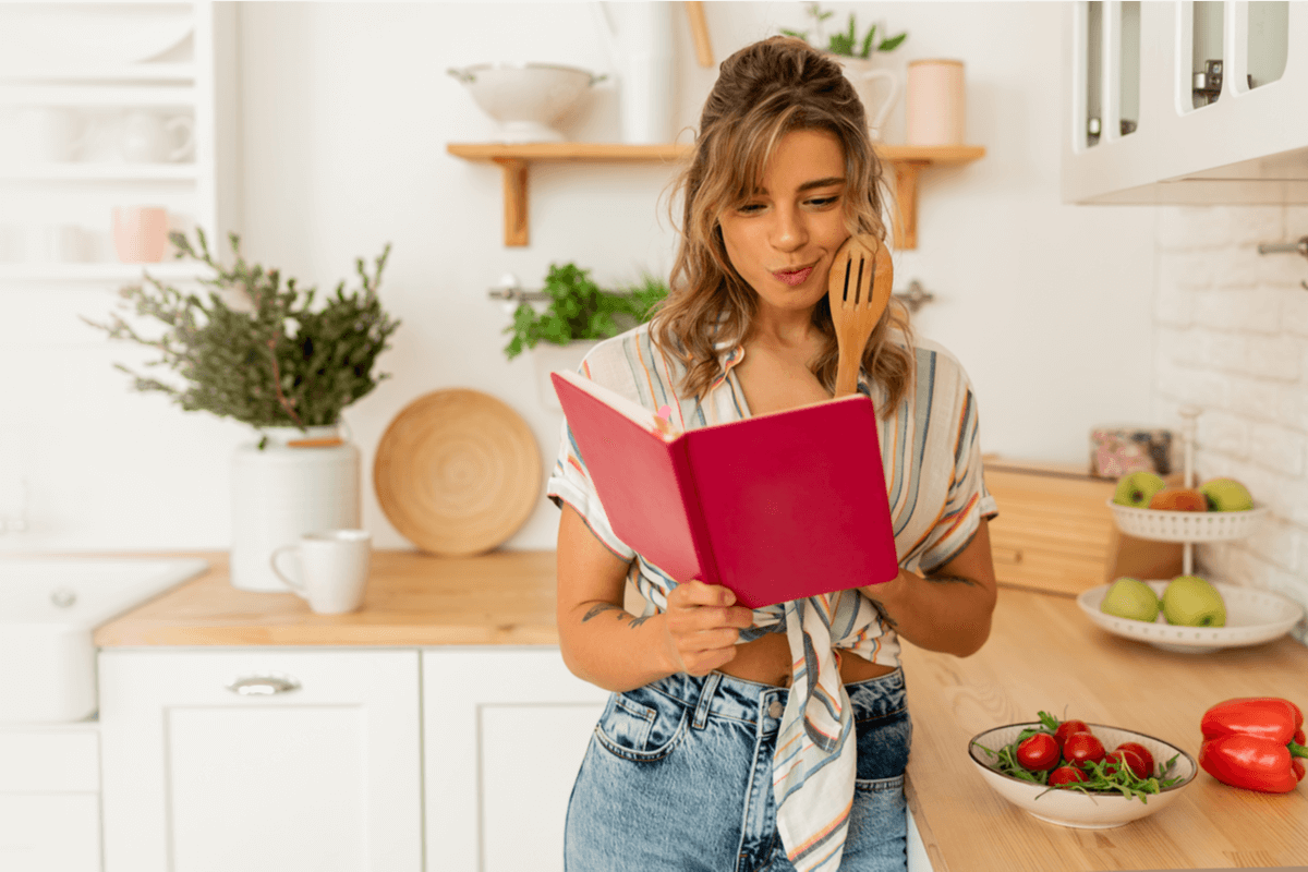 femme regardant un livre de recettes