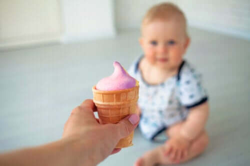 la main adulte offre de la crème glacée à un bébé