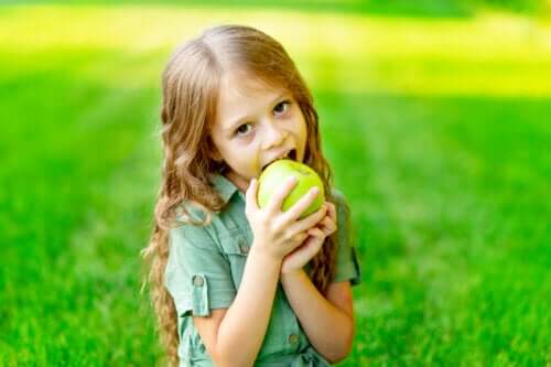 petite fille mange des dents saines pomme verte