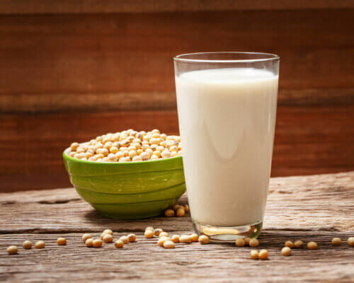 Haricots de soja à côté d'un verre de lait de soja.