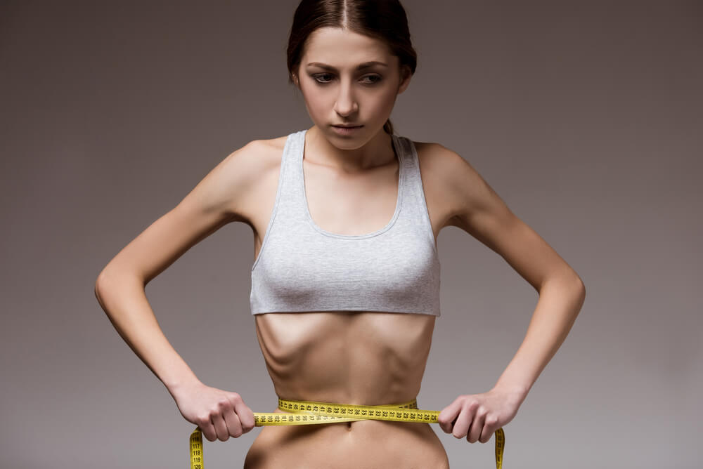 femme maigre mesurant son tour de taille