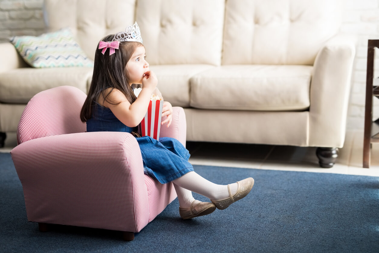 petite fille mangeant du pop corn devant la télévision