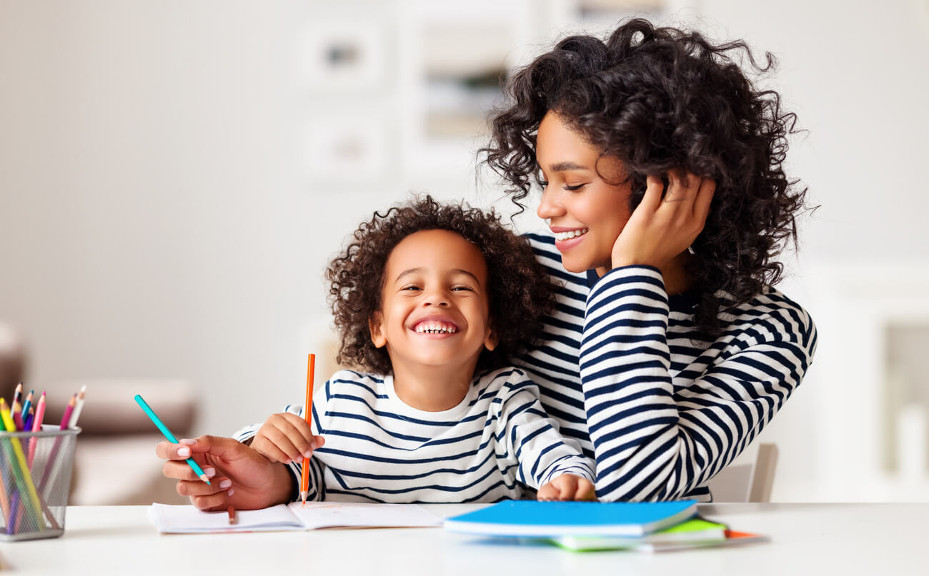 mère et son fils riant en faisant des devoirs