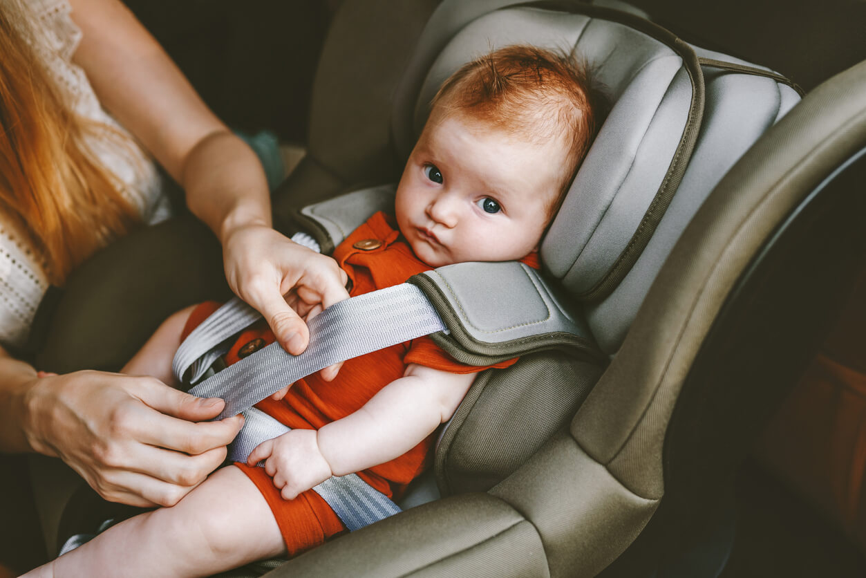 bébé étant attaché sur son siège auto