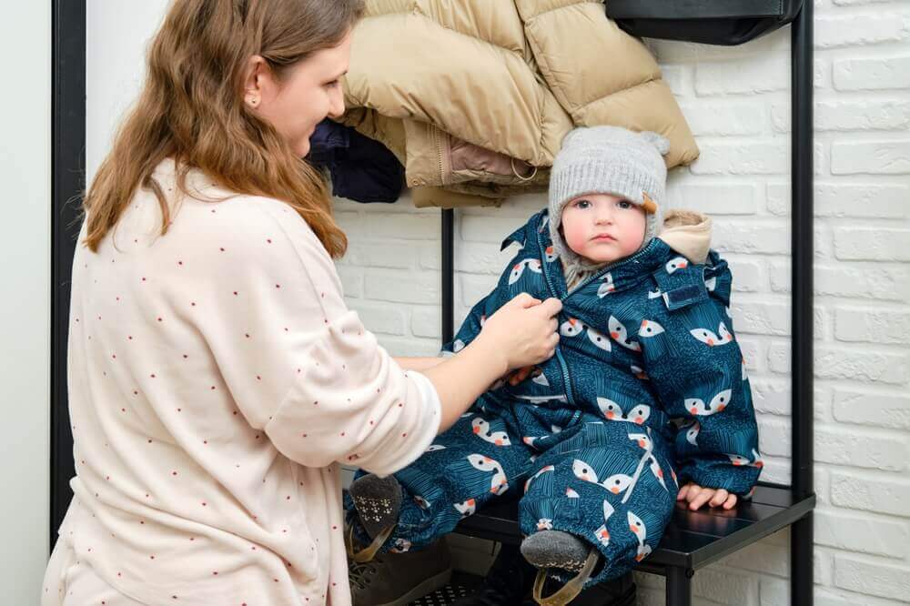 Une maman qui habille son bébé.