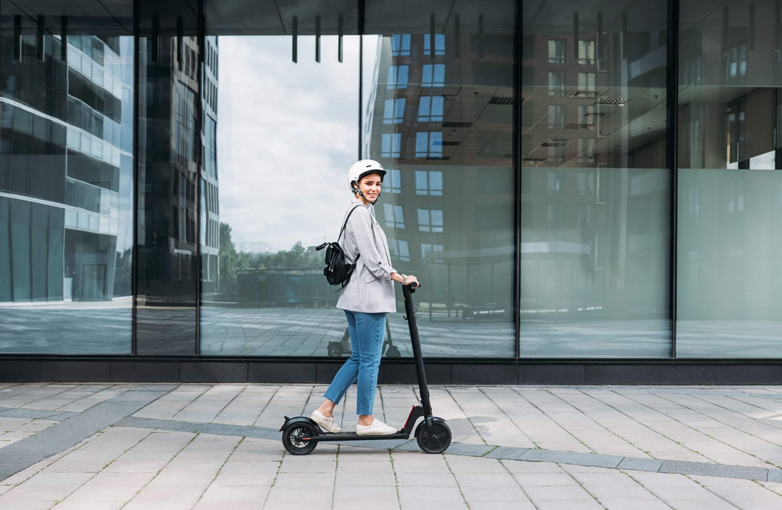 Une adolescente sur une trottinette électrique.