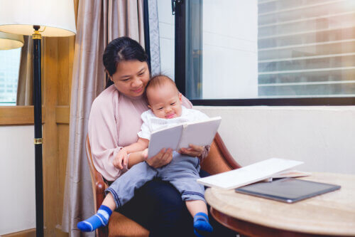 Maman lit un livre de poésie pour enfants à son bébé.